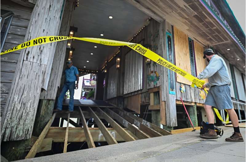 A restaurant owner closes the entrance to his establishment in Cedar Key, Florida as preparations are made for the arrival of Hurricane Helene